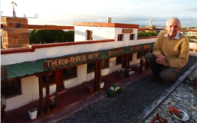 Coenie van Dyk sit hier by sy uitbeelding van 7de Laan in sy tuin in De Kelders wat â€˜n tyd gelede deur die Pasella-span van SABC2 besoek is. Dit word eerskomende Vrydagaand, 22 Mei 2015 om 18:00 gebeeldsend en word Sondag om 14:00 herhaal. Coenie se volledige tuin bestaan uit realistiese uitbeeldings van 7de Laan, â€˜n volledige â€œplaasâ€ met alles wat daarmee saamgaan en veel meer, asook â€˜n spoorwegstasie wat hy onlangs gefinaliseer het. Kyk gerus Vrydagaand of Sondagmiddag na Pasella op SABC2.